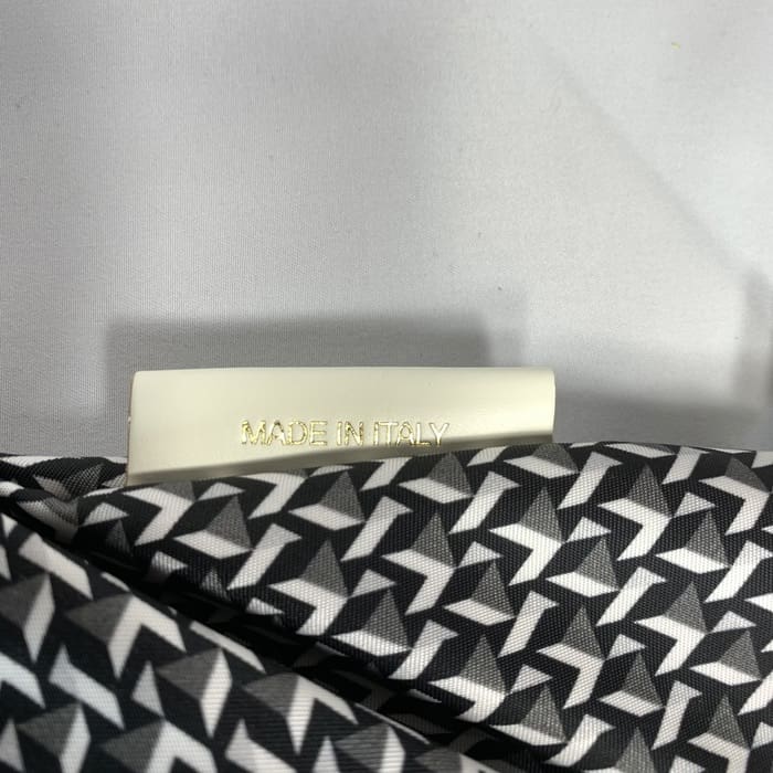 ROBERTA PIERI's zwart-witte geometrische mini-plunjezak met een wit label met de tekst "MADE IN ITALY" in gouden letters. De achtergrond is effen wit.