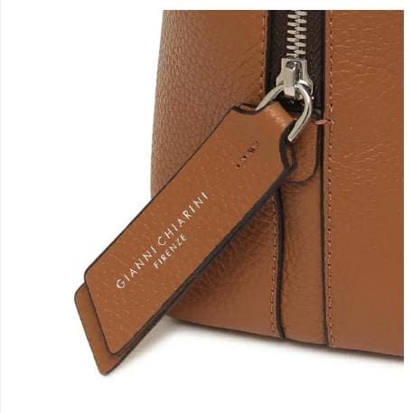 Close-up van de bruine leren tas van GIANNI CHIARINI. Het heeft een metalen ritssluiting en een leren label met de tekst "GIANNI CHIARINI FIRENZE" in het wit. Het is gemaakt in Italië en straalt tijdloze Italiaanse elegantie uit.